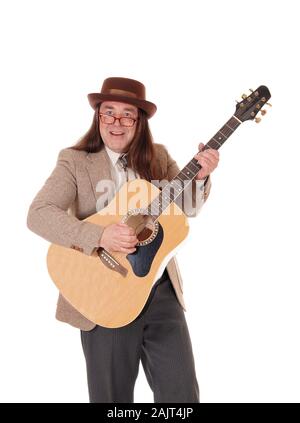 Un bel homme autochtone dans une veste, pantalon jeans et un chapeau de cowboy et permanent à jouer de la guitare, isolée pour fond blanc Banque D'Images