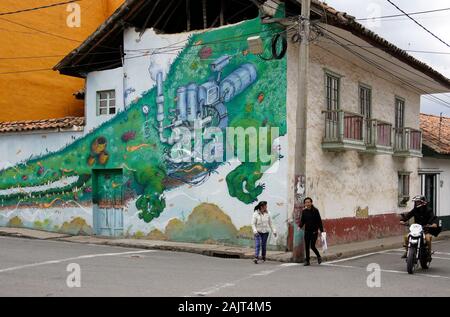 Murale colorée peinte pour Cliber sacs à dos sur le toit de tuile bâtiment colonial dans Nemocon, Colombie, artiste urbain par Wosnan Banque D'Images