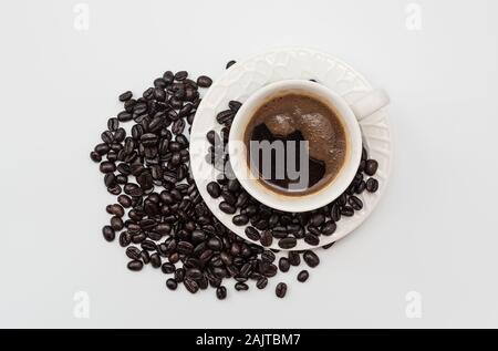 Vue de dessus de la tasse de café blanc avec grains de café isolé sur fond blanc Banque D'Images