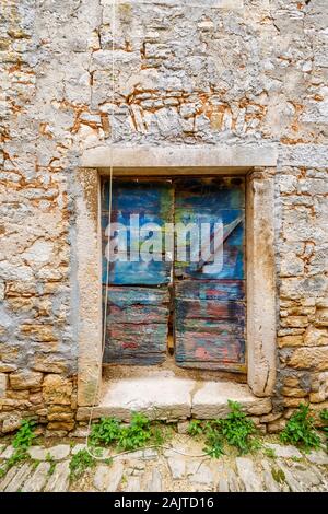 Portes en bois coloré d'une porte dans un mur en pierre dans la vieille ville dans la balle, une petite ville sur la colline du Mont Perin en Istrie, Croatie Comté Banque D'Images