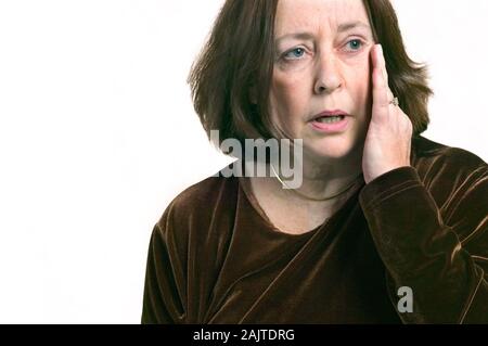 Portrait d'un inquiet à la moyen-âge femme tenant sa tête avec sa main sur un fond blanc Banque D'Images