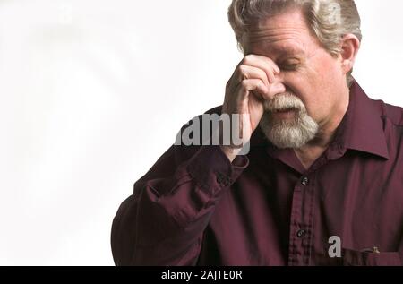 Portrait d'un homme d'âge moyen avec des maux de tête sur un fond blanc Banque D'Images