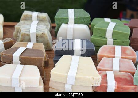 Les savons artisanaux colorés avec des ingrédients marqués sur bandes blanches dans un marché Banque D'Images