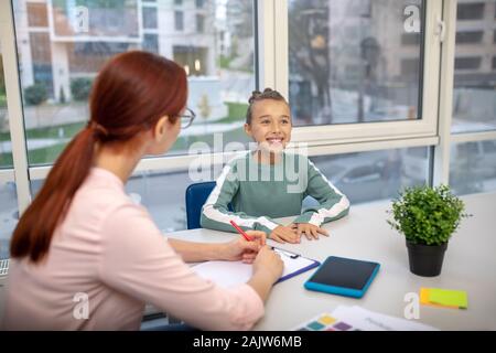 Jeune écolière travailler avec son professeur individuellement Banque D'Images