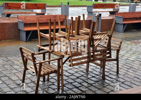 Wet tables et chaises sur la rue devant le restaurant de la ville après la pluie, gros plan. Banque D'Images