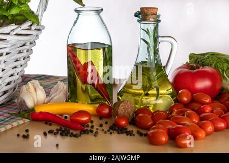 Les bouteilles avec de l'huile aromatisée. Saveurs de l'Italie. Le basilic, le poivre et l'ail. La préparation d'une salade.. Les tomates et saveurs de pizza. Banque D'Images