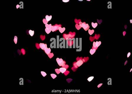 Coeur fait de peu de coeurs roses sur fond noir Banque D'Images
