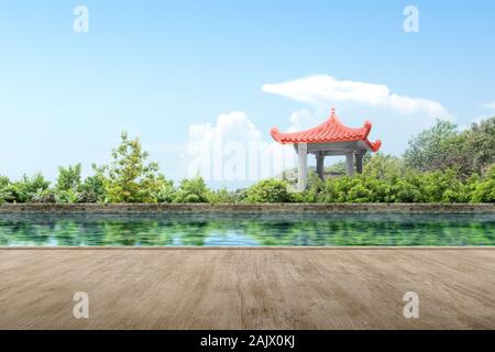 Wooden path avec gazebo chinois bâtiment avec étang et arbres sur le parc Banque D'Images