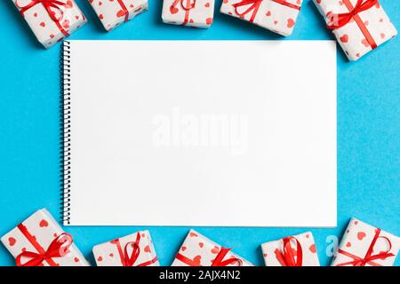 Vue de dessus de l'ordinateur portable entouré de coffrets cadeaux sur fond coloré. Concept de la Saint-Valentin. Banque D'Images