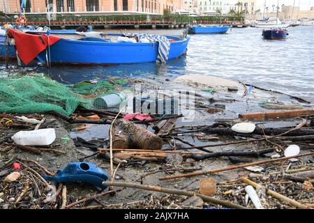 Microplastic et en plastique et les déchets des déchets flottant dans l'eau avec filet de pêche et bateau en bois sur l'arrière-plan. L'océan et sur la mer de la pollution en plastique Banque D'Images