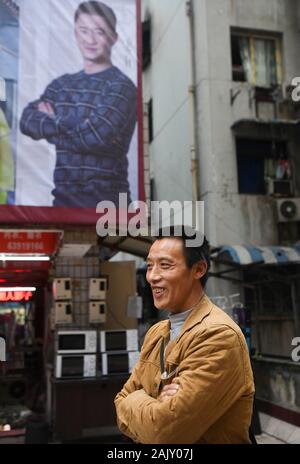 (200106) -- CHONGQING, le 6 janvier 2020 (Xinhua) -- Ran Guanghui attend les clients à proximité d'un centre commercial à Chaotianmen dans le sud-ouest de la Chine, la municipalité de Chongqing, le 5 janvier 2020. Ran Guanghui, 50 ans, a gagné sa vie comme un "bang bang", littéralement "rester les hommes", à Chongqing pendant dix ans. Dans une ville de montagne comme Chongqing, avec une abondance de routes vallonnées et de sentiers, stick men ont aidé les personnes par transport des bagages et objets lourds. Transporter des marchandises sur les poteaux de bambou en équilibre sur leurs épaules, le bâton du pain gagné les hommes à la sueur de leur front. Ran est devenu l'un d'entre eux en 2009 alors qu'il fa Banque D'Images