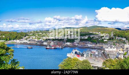 Une vue panoramique d'Oban sur la côte ouest de l'Écosse, montrant la ville, les gares maritimes et les collines en arrière-plan, pris sur une journée ensoleillée Banque D'Images