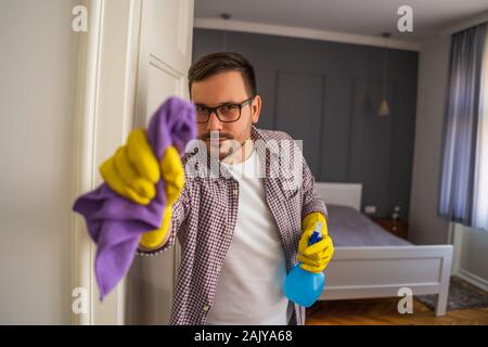 Jeune homme est obsessionnellement le nettoyage de l'appartement. Banque D'Images