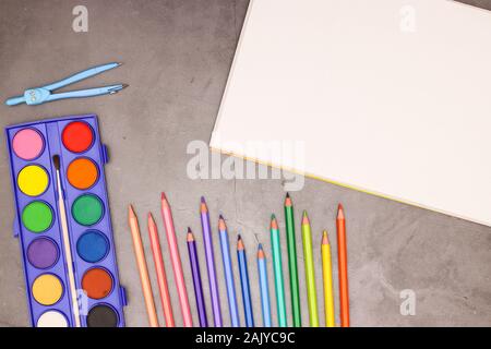 Retour à l'école - bloc dessin blanche et de l'école et des fournitures artistiques sur fond gris Banque D'Images