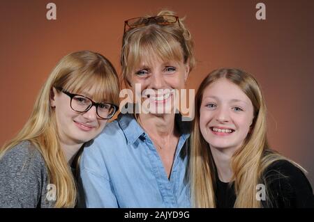 Très jolie jeune femme et ses deux filles adolescentes jolie blonde sur un arrière-plan gradué Banque D'Images