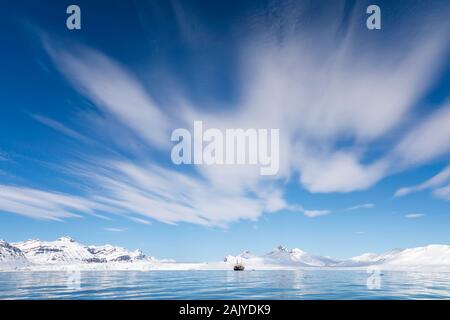 Voile sur les fjords du Svalbard, un archipel norvégien entre la partie continentale de la Norvège et le pôle Nord, avec les montagnes enneigées et vaste fond de ciel bleu. Banque D'Images