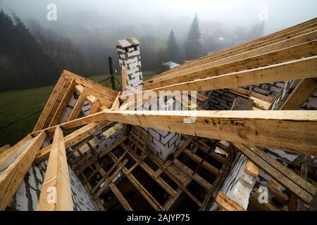 Vue de dessus du châssis de toit en bois poutres de bois et de planches sur les parois en blocs isolants en mousse creux. Bâtiment, construction, toitures et renovat Banque D'Images