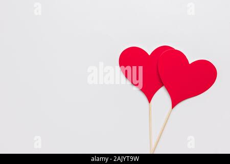 Stock photo de deux coeurs en papier rouge sur un fond blanc. Les coeurs ont un stick Banque D'Images