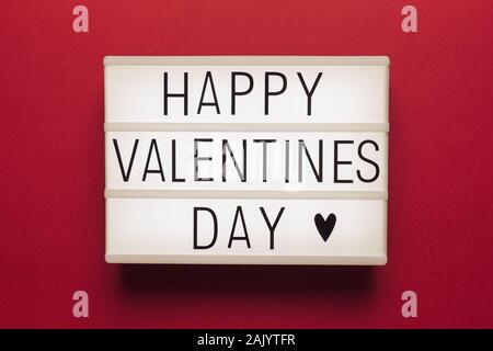 Stock photo d'une boîte à lumière blanche, sur un fond rouge et noir des lettres avec le texte "Happy Valentines Day' Banque D'Images