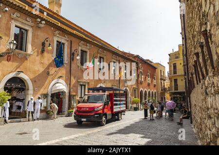 Taormina en Sicile, Italie - 9 juillet 2019 : camion rouge garée en face de l'hôtel de ville de la vieille ville Banque D'Images