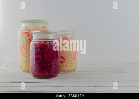 Trois pots de verre de blanc fermenté, chou rouge. des légumes sur un fond clair. la fermentation est une source de probiotiques. copy space Banque D'Images