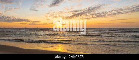 Panorama d'un coucher de soleil sur la mer du Nord, vue de la côte néerlandaise. Banque D'Images