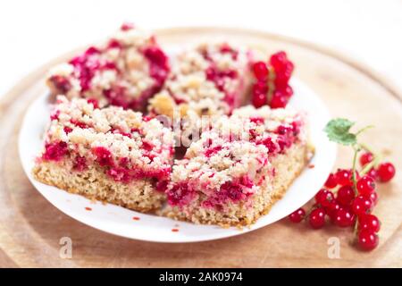 morceaux de tarte au cassis maison sur une assiette, avec cassis en bois rond, fond blanc Banque D'Images