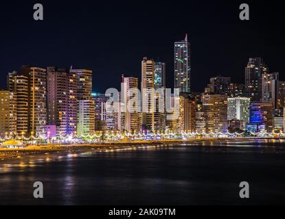 Night skyline de Benidorm avec beaucoup de lumières de l'éclairage de gratte-ciel la plage, la côte et la mer Méditerranée quand arrive o la rive. Hori Banque D'Images