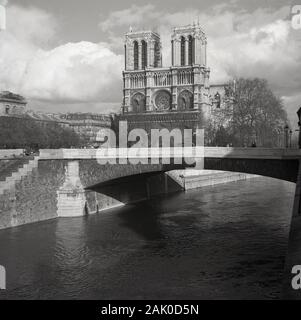 Années 1950, historique, une vue de l'ère de l'autre côté de la rivière Seine du célèbre monument, la cité médiévale de la Cathédrale Notre-Dame, Paris, France, considéré comme l'un des plus beaux exemples de l'architecture gothique française. Banque D'Images