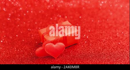 Deux coeurs rouges et boîte cadeau rouge sur fond rouge de l'étincelle. Saint Valentin, l'amour, roman, datant, cadeau, anniversaire, concept actuel bannière longue Banque D'Images