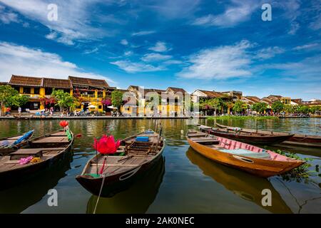 Bateaux traditionnels en bois sur la rivière Thu Bon avec de vieux bâtiments jaune dans l'ancienne ville de Hoi An, Vietnam Banque D'Images