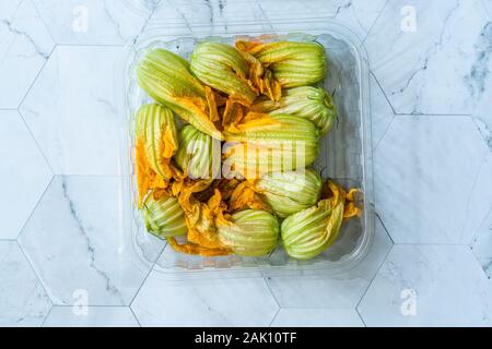 Squash Blossoms Fleurs de courgettes dans la plaque / Fleurs de courgettes comestibles dans un coffret plastique Package / Conteneur. L'alimentation biologique. Banque D'Images