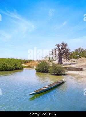 Bateau en bois coloré traditionnel sur la rivière dans une lagune de la mer et ciel magnifique dans l'arrière-plan, l'Afrique, au Sénégal. Banque D'Images