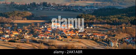 Village de Bohême du Sud avec église - éclairé par le soleil levant, paysage rural avec forêts, champs et prairies autour (Sobenov, république tchèque) Banque D'Images