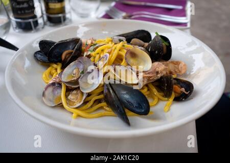 Les pâtes italiennes avec fruits de mer - moules, vongole et les crevettes. Libre de pâtes aux fruits de mer servi dans un restaurant italien. Une cuisine méditerranéenne. Banque D'Images