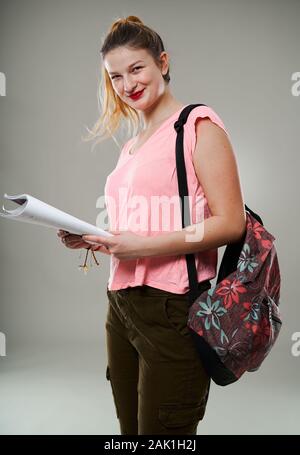 Jeune étudiante fille avec sac Studio shot isolé sur gray Banque D'Images