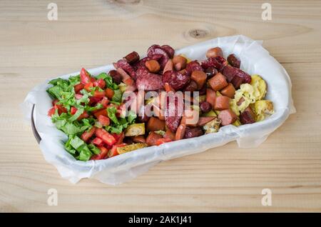 Salchipapa frais grillé, et les tranches de saucisse de porc péruvienne de pommes de terre frites, sur table en bois Banque D'Images