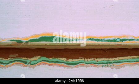 Le ponçage d'une maison de bois blanc, préparation pour la peinture, révèle quatre couleurs maison précédente Banque D'Images