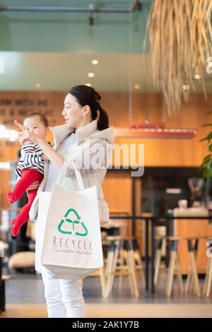 Visiter femme recycle shop Banque D'Images