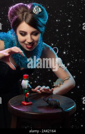 Fille en costume reine de la souris joue avec Casse-noisette toy sur stars de fond Banque D'Images