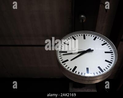 Vieille horloge ronde simple accroché au plafond en bois en décoration café sur fond sombre avec copie espace. Banque D'Images