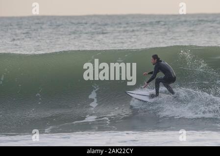 Un homme surf au large de la côte de l'Ano Nuevo State Park dans le comté de San Mateo en Californie. Banque D'Images