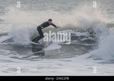 Un homme surf au large de la côte de l'Ano Nuevo State Park dans le comté de San Mateo en Californie. Banque D'Images