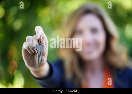 Clés de maison En Main de la femme de Realtor ou de l'acheteur à la maison Banque D'Images