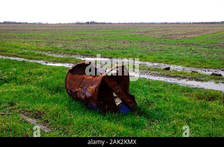 Un vieux tambour à huile rouillée sur les terres arables au Norfolk à Somerton, Norfolk, Angleterre, Royaume-Uni, Europe. Banque D'Images