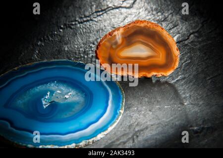 Portrait d'un mince disque poli d'une table ronde avec agate circulaire bleu bagué et grain moyen (druse) trou entouré de structures cristallines. Banque D'Images