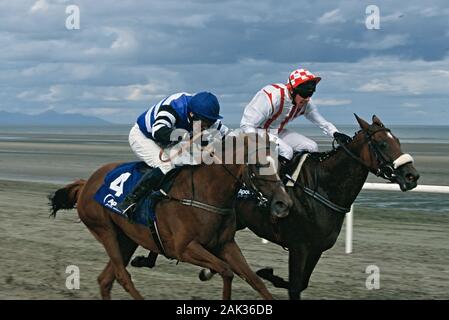 Deux jockeys poussant leurs chevaux de course sur la piste de course à la plage de Laytown dans les Midlands à la côte orientale de l'Irlande. (Photo non datée) | Banque D'Images