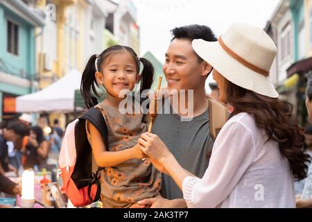 Bonne petite famille chinoise qui mange des encas sur le marché Banque D'Images