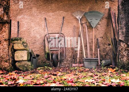 Outils de jardin rustique contre un mur à l'automne, processus vintage Banque D'Images