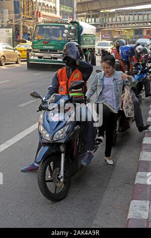 Bangkok, Thaïlande - 2020.01.04 : moto taxi chauffeur ramasser une passagère à Sukhumvit Soi thonglor 55 Banque D'Images